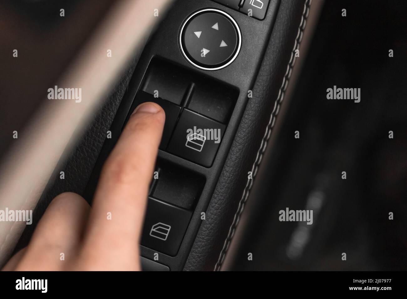 Hand pressing window buttons inside luxury car. Automatic power ...