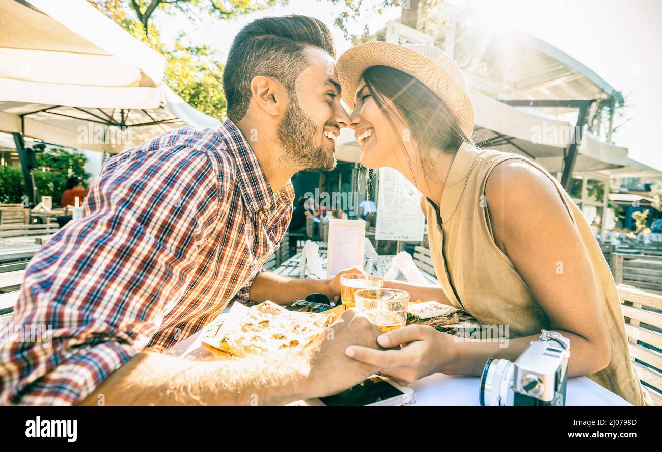 Couple in love kissing at bar eating local delicacie on travel excursion - Young happy tourists enjoying moment at street food restaurant - Relationsh Stock Photo