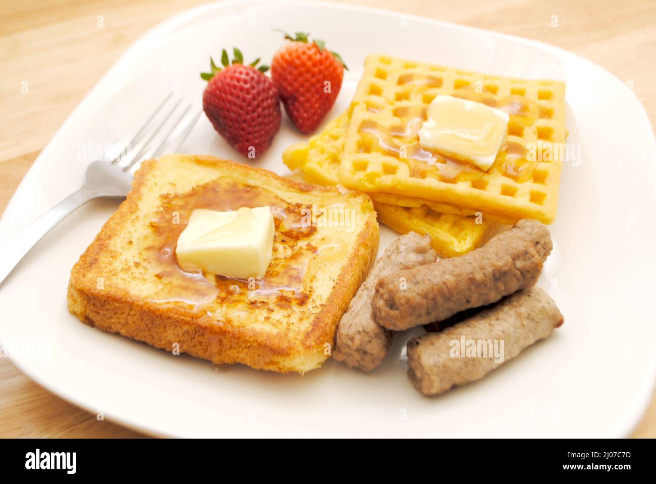 French Toast, Waffles and Two Pork Sausage Links on a White Plate Stock Photo