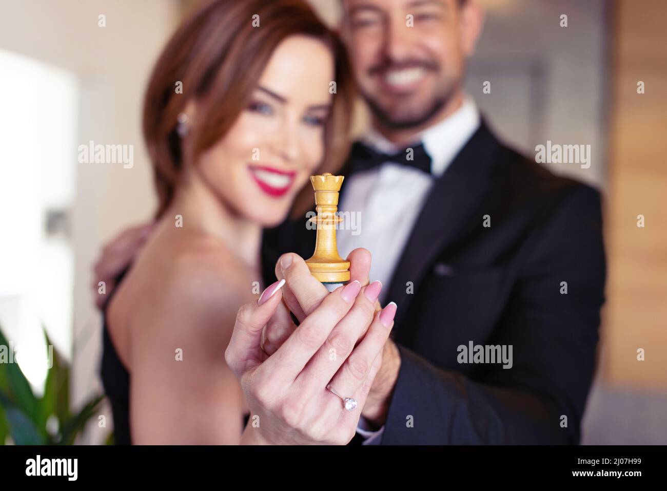 Happy young couple holding white chess queen concept, success in relationship and marriage Stock Photo