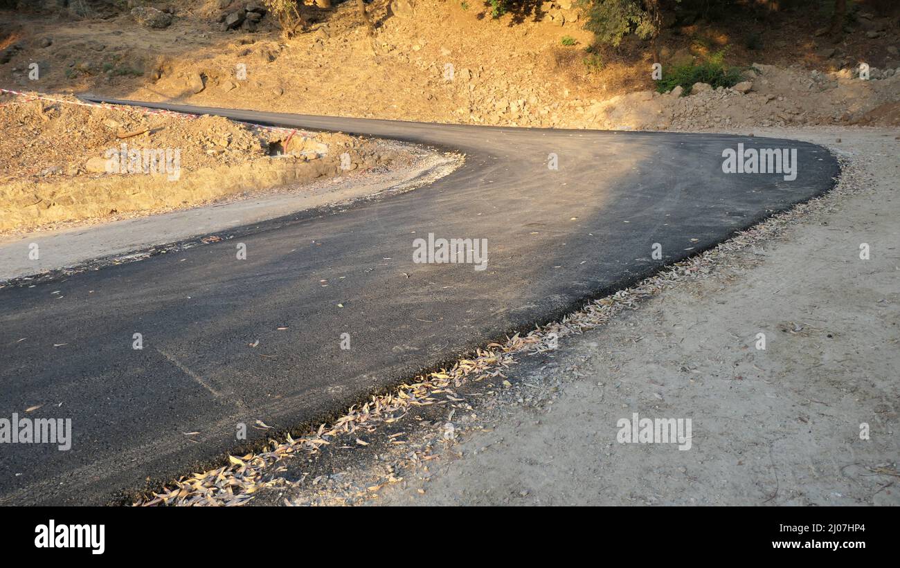 Newly tarmacked road without markings on rural hillside in Andalusia, Spain Stock Photo