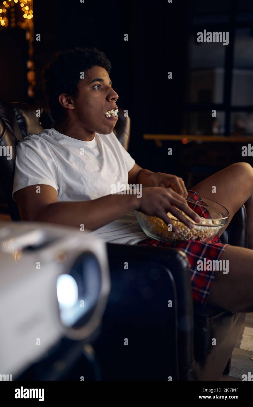 Guy with bowl of popcorn watching movie Stock Photo Alamy