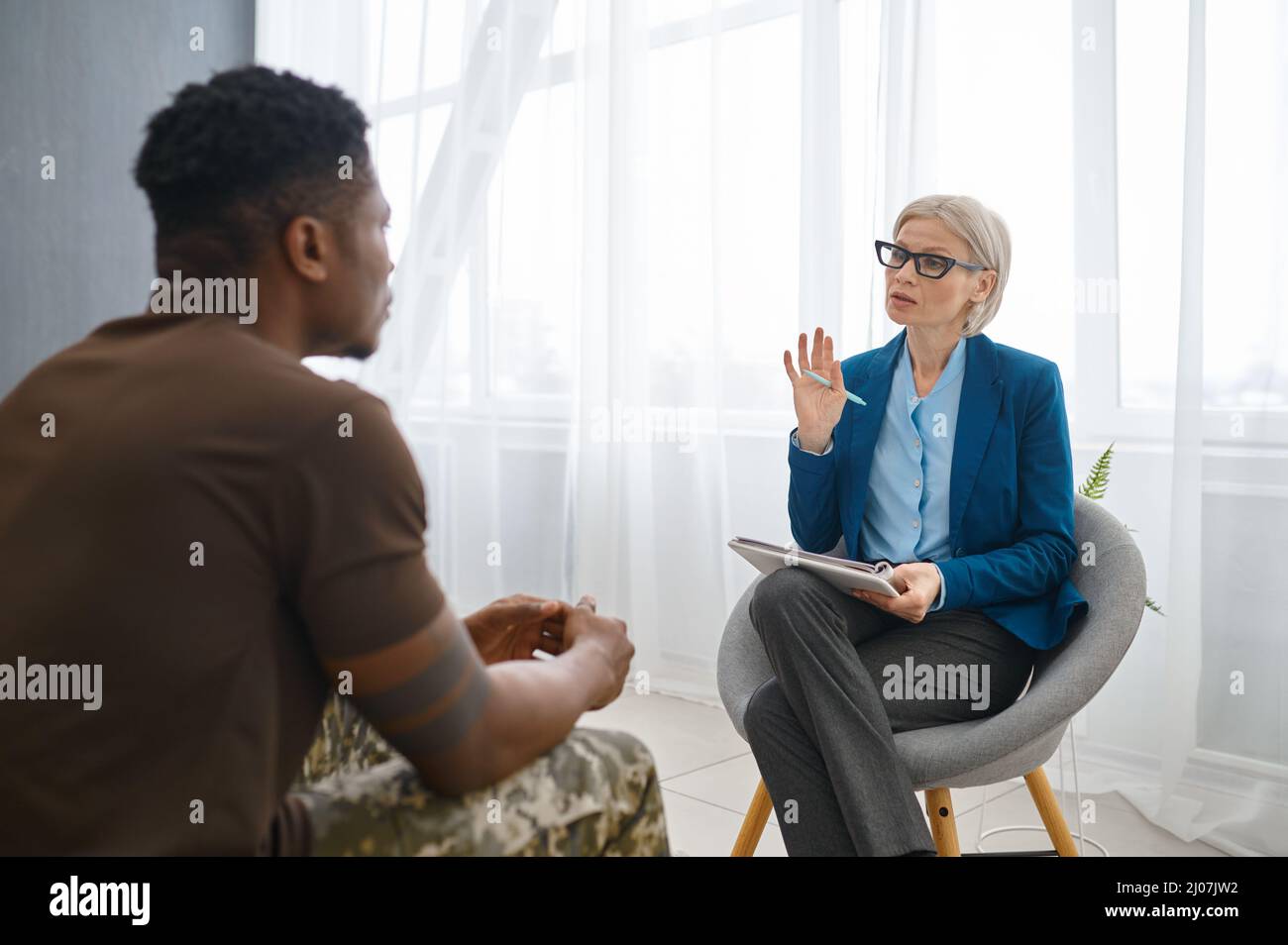 Professional psychologist giving advice to military patient Stock Photo