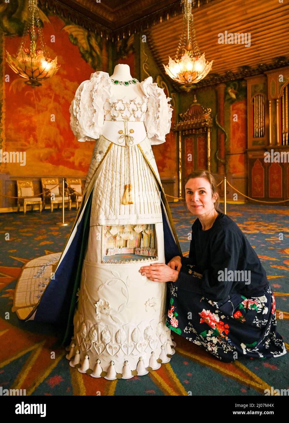Brighton UK 17th March 2022 - Artist Stephanie Smart with her Symphony of Stars life-sized court dress in the Music Room at the launch of the Brighton Royal Pavilion's Regency Wardrobe exhibition which opens to the public on Saturday 19th March . The Regency Wardrobe is a collection of imagined garments reflecting the fashion, style and history of the Regency period created by artist Stephanie Smart  : Credit Simon Dack / Alamy Live News Stock Photo