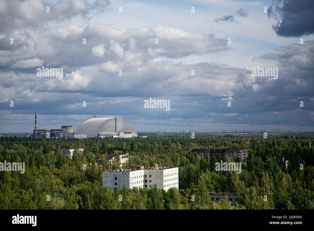A distance view of the arch-shaped New Safe Confinement structure installed in 2016 to contain the remains of Chernobyl's number 4 reactor unit which was destroyed during the historical Chernobyl nuclear disaster in 1986 due to the meltdown and explosion of the nuclear reactor. The situation of the Chernobyl nuclear plant remains at high risk according to the Ukrainian government since the Russian Force captured the area. The Russian Force repeatedly halt the energy supply to the nuclear plant which was used to cool down the core of the destroyed number 4 nuclear plant. However, the Internatio Stock Photo