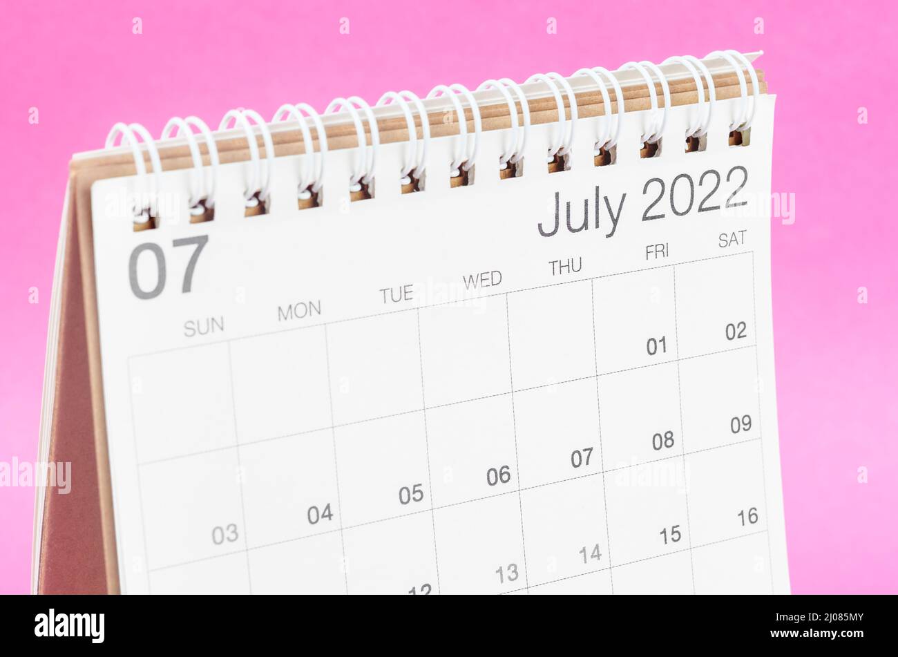 The July 2022 desk calendar on pink background with empty space. Stock Photo