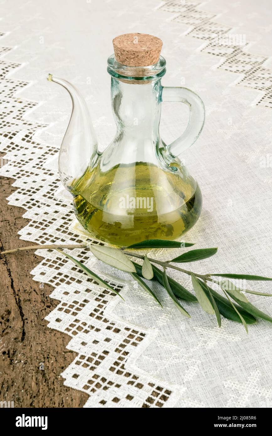 Extra virgin olive oil in a rustic glass jar on a vintage wooden ...