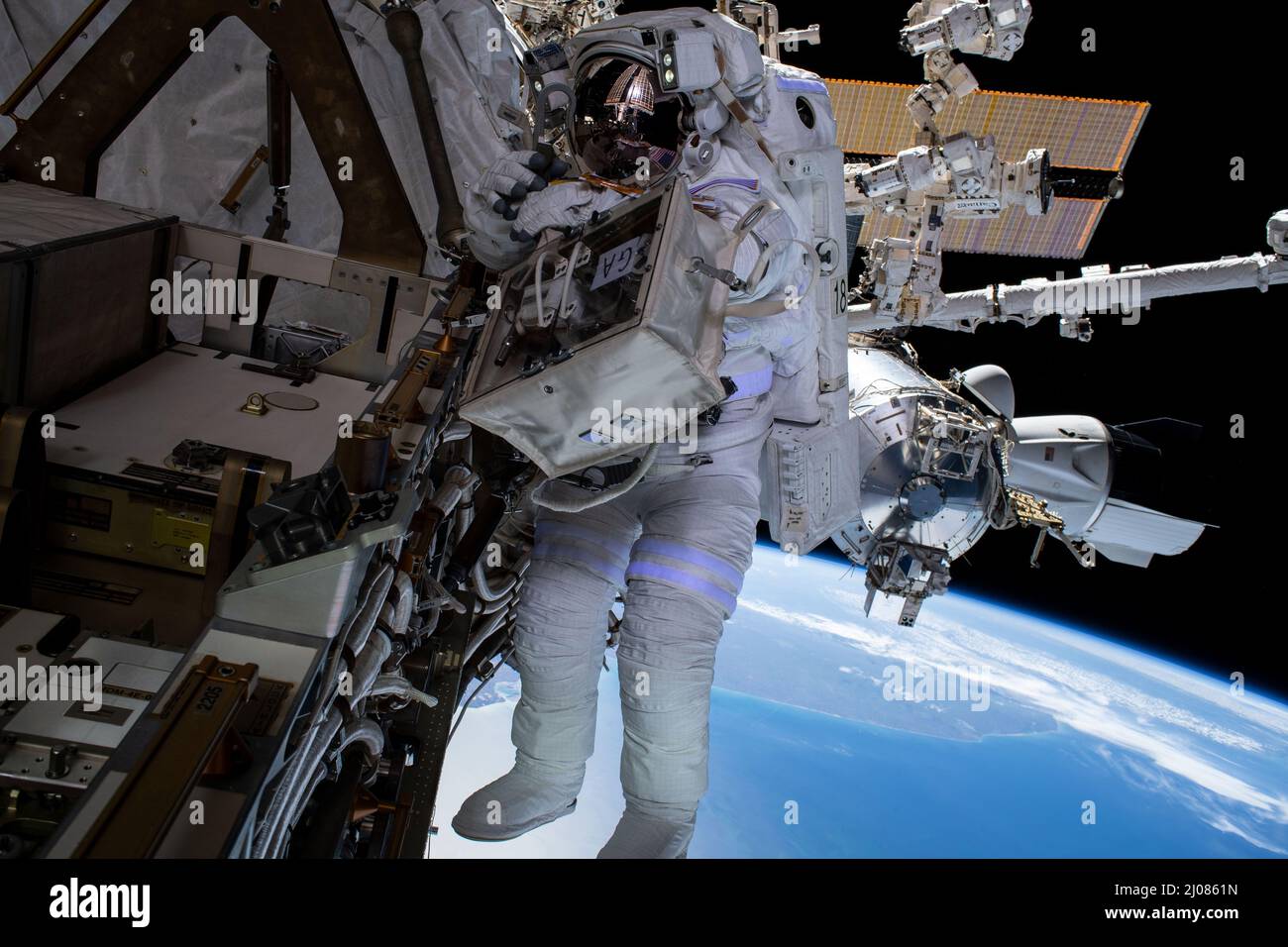 International Space Station, Earth Orbit. 15th Mar, 2022. International Space Station, EARTH ORBIT. 15 March, 2022. NASA astronaut Raja Chari, during a nearly 7 hour long spacewalk to prepare the International Space Station for the next roll-out solar array, March 15, 2022 in Earth Orbit. At right, is the SpaceX Crew Dragon Endurance docked to the Harmony module with the Atlantic coast of South America 268 miles below. Credit: NASA/NASA/Alamy Live News Stock Photo