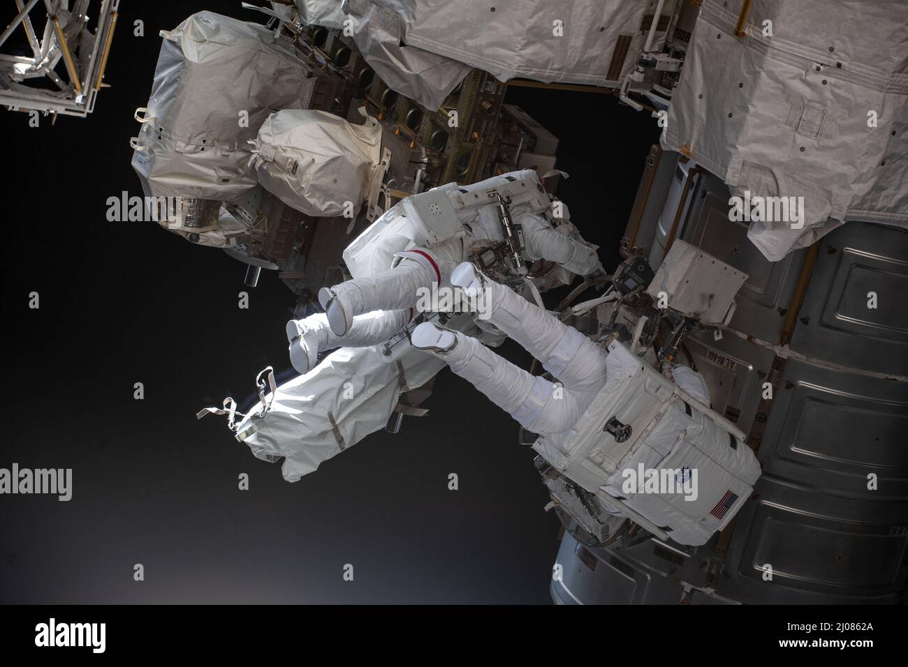 International Space Station, Earth Orbit. 15th Mar, 2022. International Space Station, EARTH ORBIT. 15 March, 2022. NASA astronauts Kayla Barron, left, and Raja Chari, right, exit the Quest airlock as they begin a nearly 7 hour long spacewalk to prepare the International Space Station for the next roll-out solar array, March 15, 2022 in Earth Orbit. Credit: NASA/NASA/Alamy Live News Stock Photo