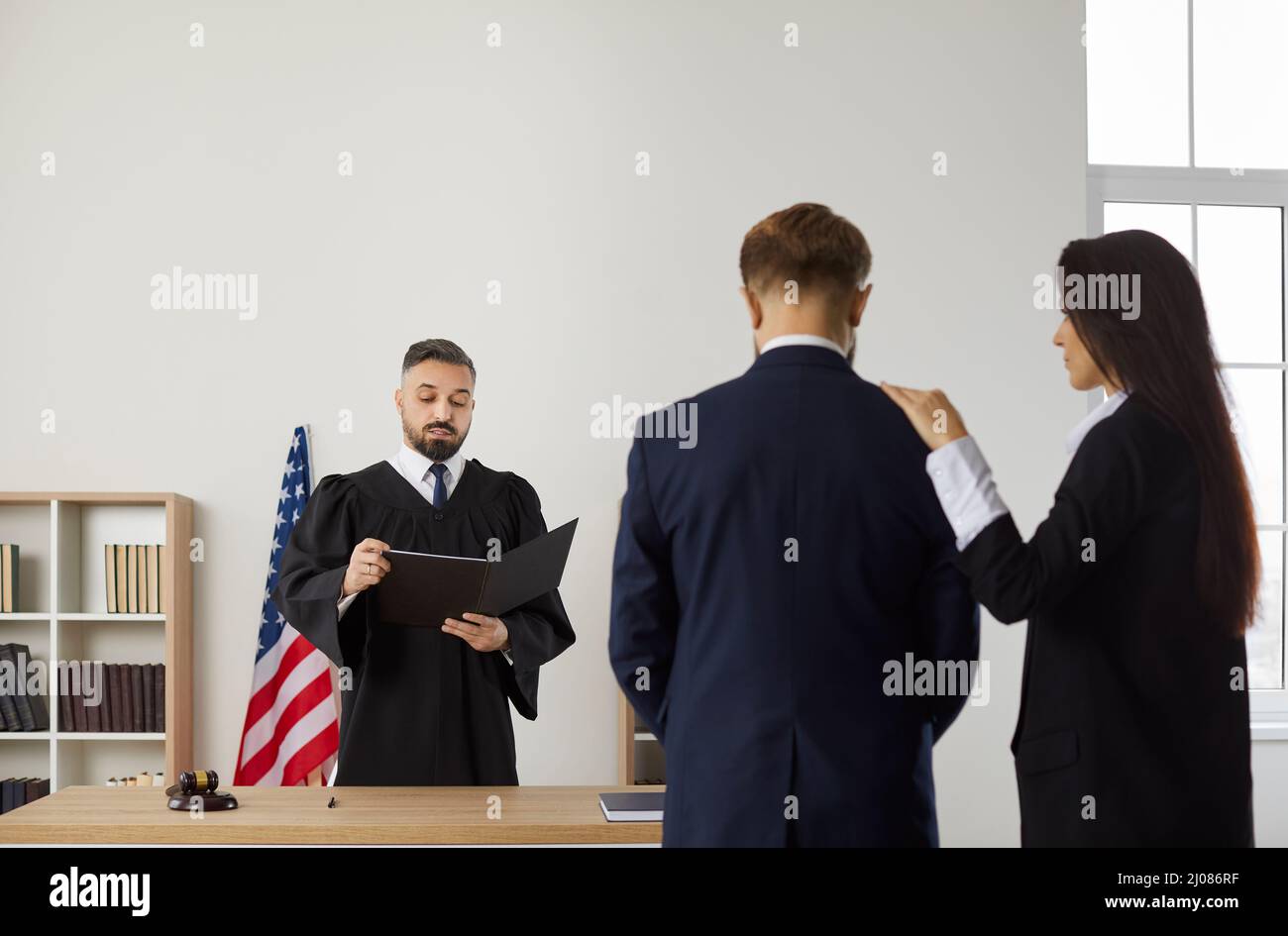 Lawyer and client listen to judge pronounce verdict Stock Photo