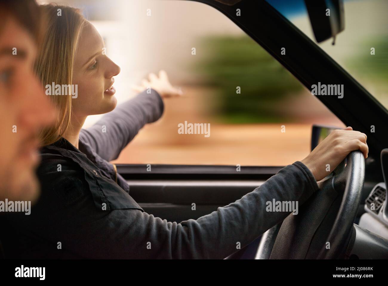 Happiness is a journey, not a destination. A happy young couple in their car enjoying a road trip. Stock Photo