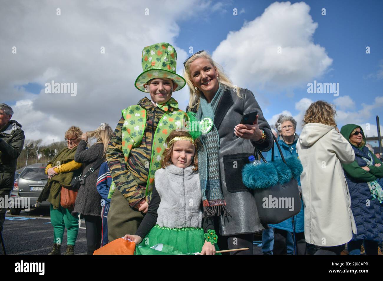Bantry, West Cork, Ireland. 17th Mar, 2022. After a long break due to the pandemic, Saint Patrick's Day celebrations are back in full swing. A large crowd of people gathered today in the square to watch the parade and enjoy the sunny day. Pictured below: Anabelle Ruban, with her mom, Mairead Ruban, and brother Joseph. Credit: Karlis Dzjamko/Alamy Live News Stock Photo