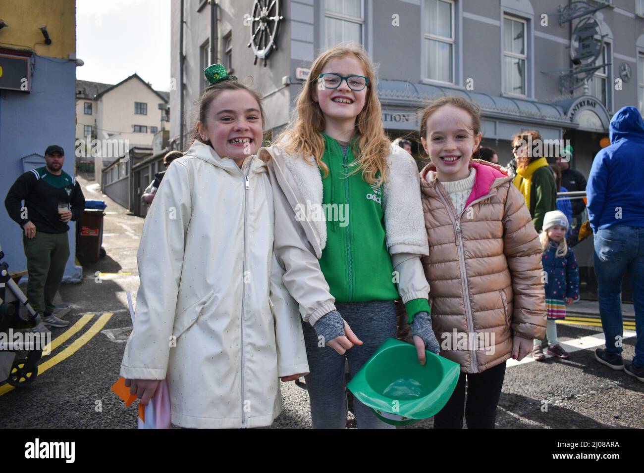 Bantry, West Cork, Ireland. 17th Mar, 2022. After a long break due to the pandemic, Saint Patrick's Day celebrations are back in full swing. A large crowd of people gathered today in the square to watch the parade and enjoy the sunny day. Pictured below: Emily, Millian and Kate. Credit: Karlis Dzjamko/Alamy Live News Stock Photo