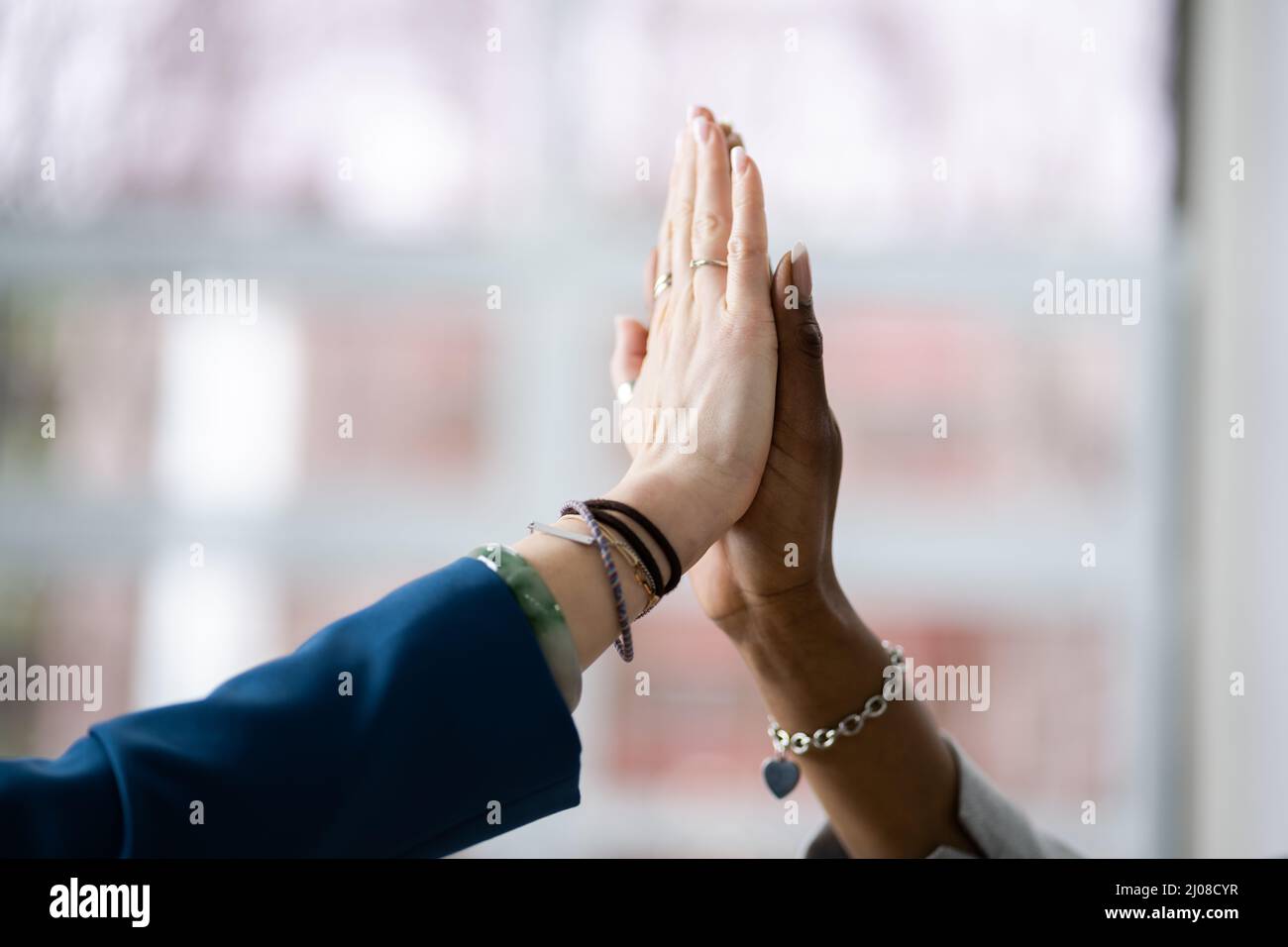 Two Smiling Young Businesswomen Giving High Five In Office Stock Photo ...