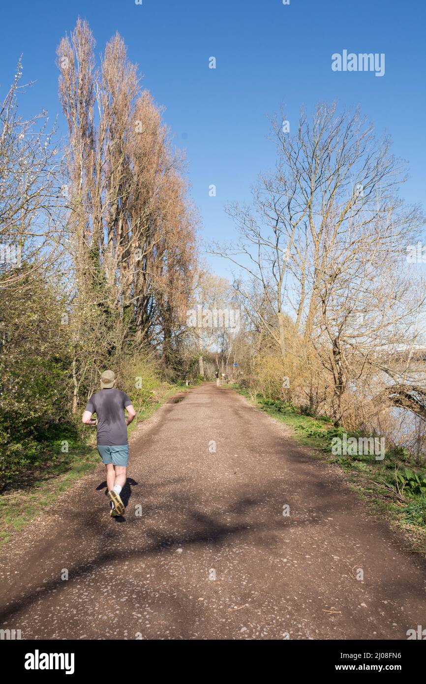 A male jogger running along the Thames Path, Putney, London, England