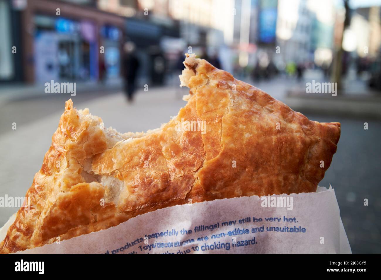 bite taken out of greggs steak bake pastry on the go in liverpool city