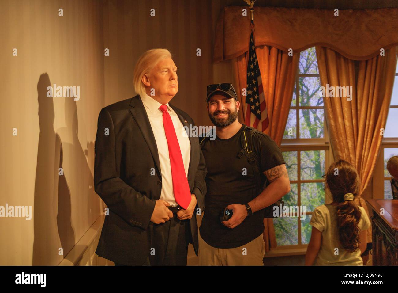 Tourist guy posing with Donal Trump wax figure in Madame Tussauds museum Stock Photo