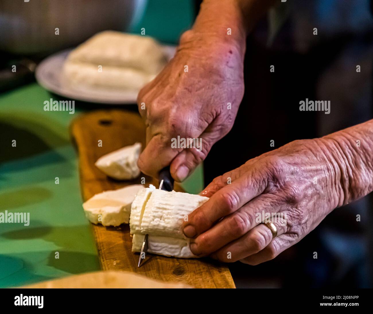 Halloumi is cut from the piece and then fried in the pan and served immediately Stock Photo