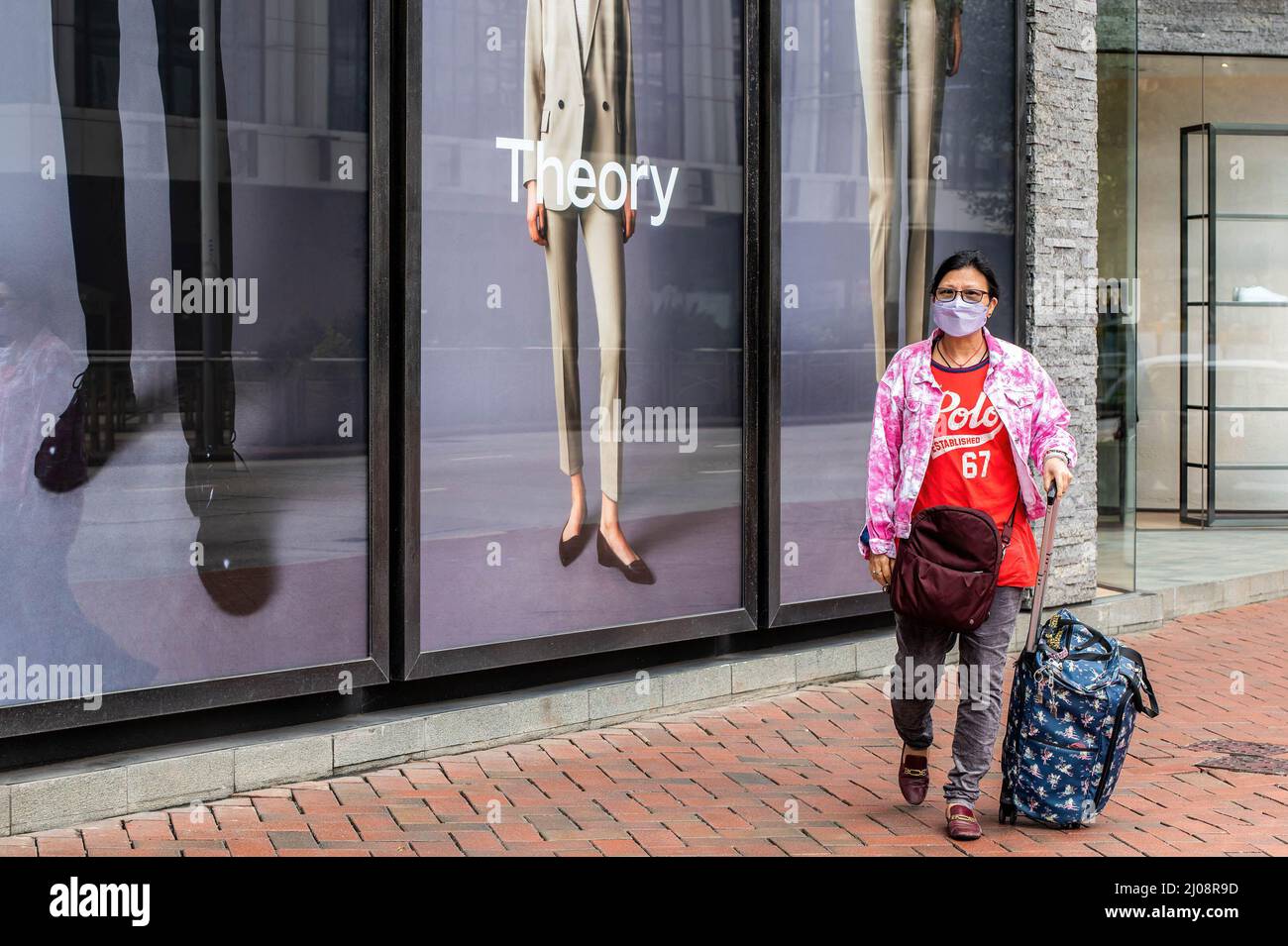 A woman wearing a surgical mask walks out of a Balenciaga store the Admiralty District of Hong Kong. According to the Hong Kong Government's economic analysis, the retail sector is facing