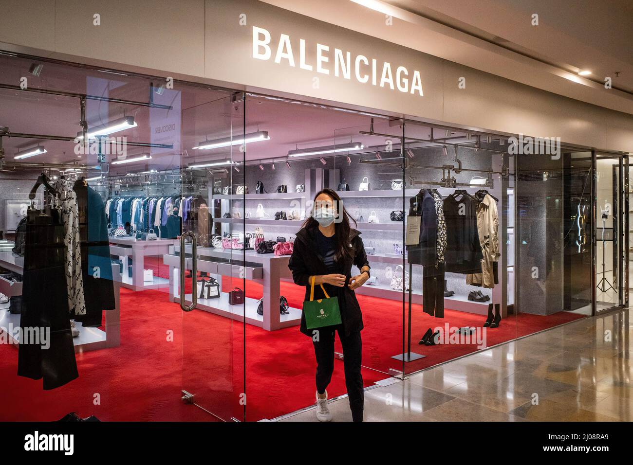A woman wearing a surgical mask walks out of a Balenciaga store in the  Admiralty District of Hong Kong. According to the Hong Kong Government's  economic analysis, the retail sector is facing