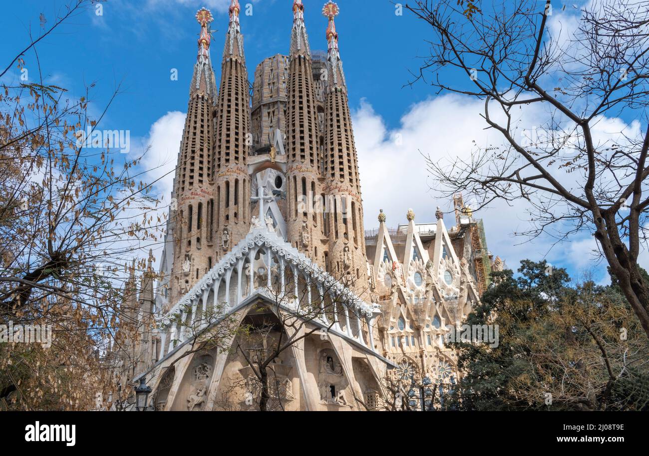 BASILICA i TEMPLE EXPIATORI de la SAGRADA FAMILIA BARCELONA SPAIN VIEW OF PASSION FACADE AND TREES Stock Photo