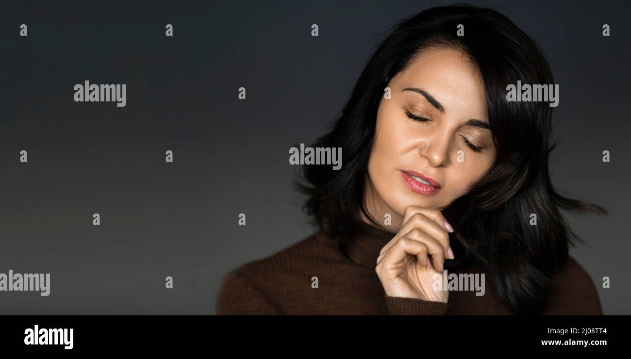 Sensual 40 years old woman with closed eyes - photo over grey background. Stock Photo
