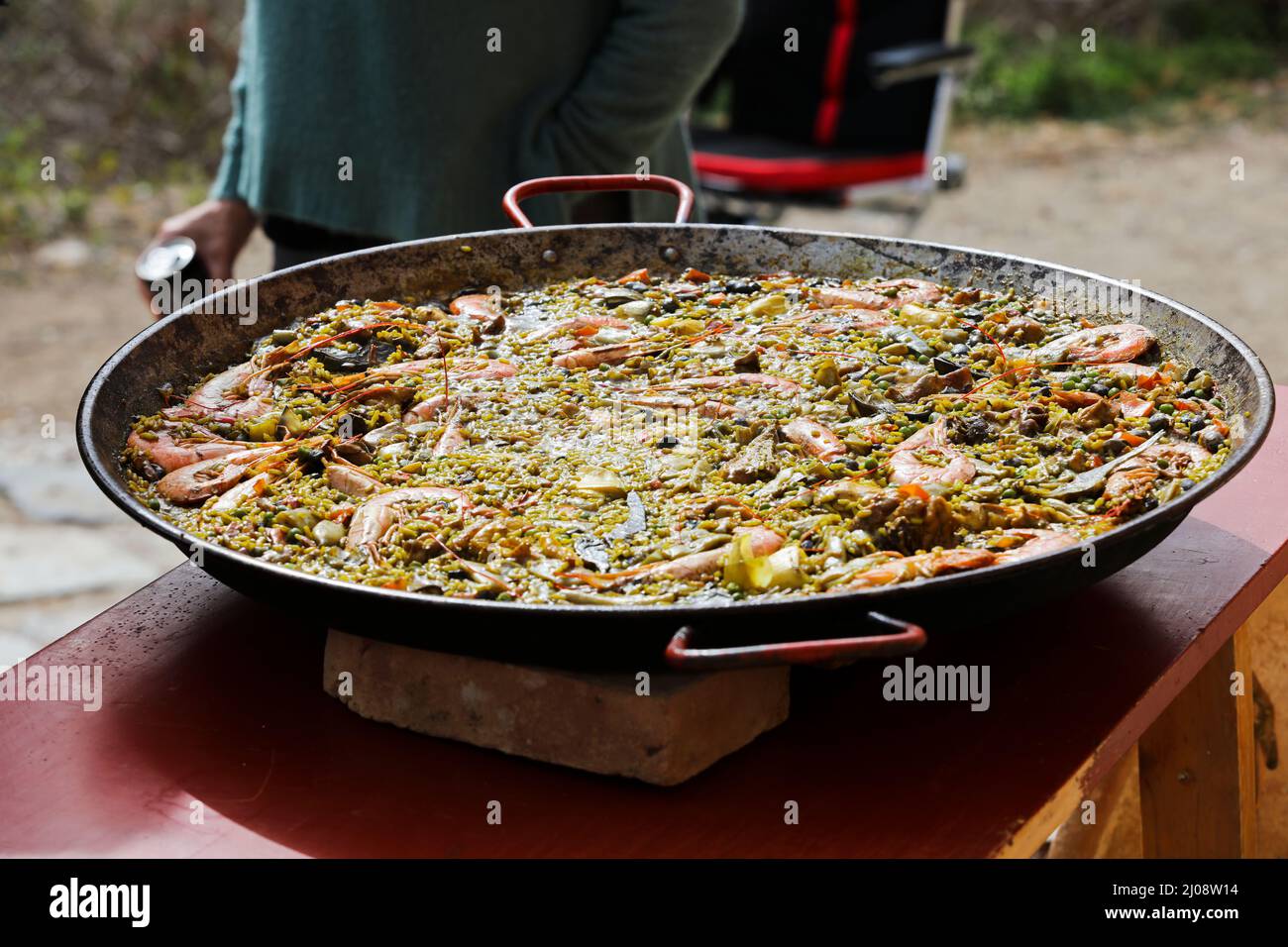 paella in the field, with fire and sunny day Stock Photo