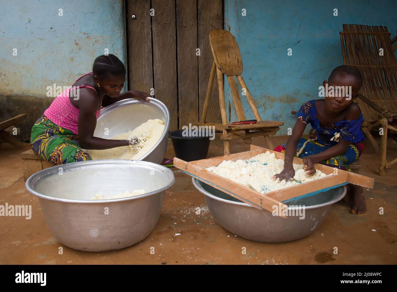 Girls processing cassava into attíeké, cassava cous cous typical of Côte d'Ivoire Stock Photo