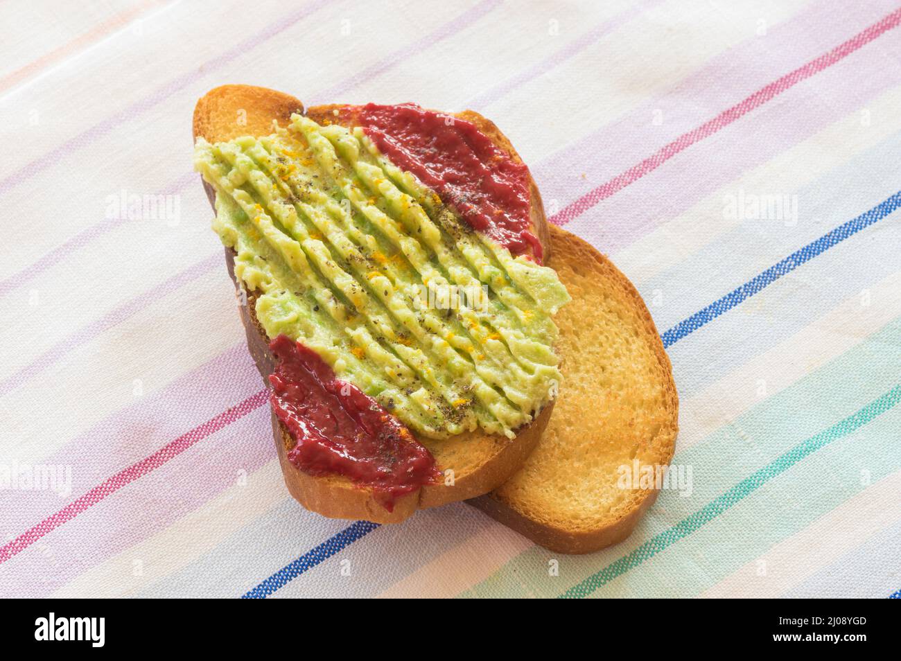 Toast with guacamole, and spicy raspberry mash Stock Photo