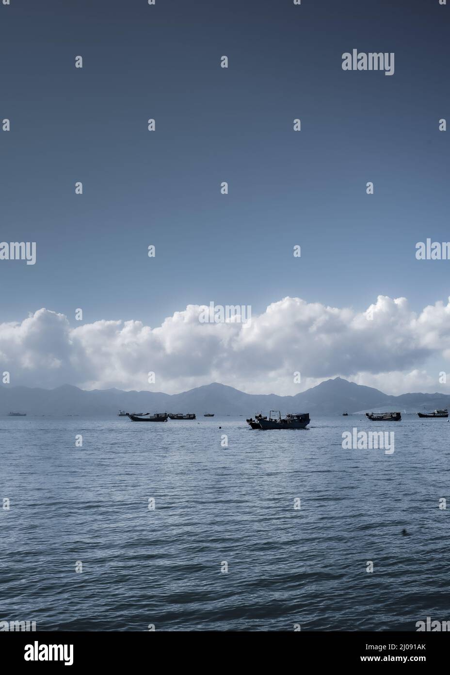 A vertical shot of fishing boats on the lake under a cloudy sky Stock ...