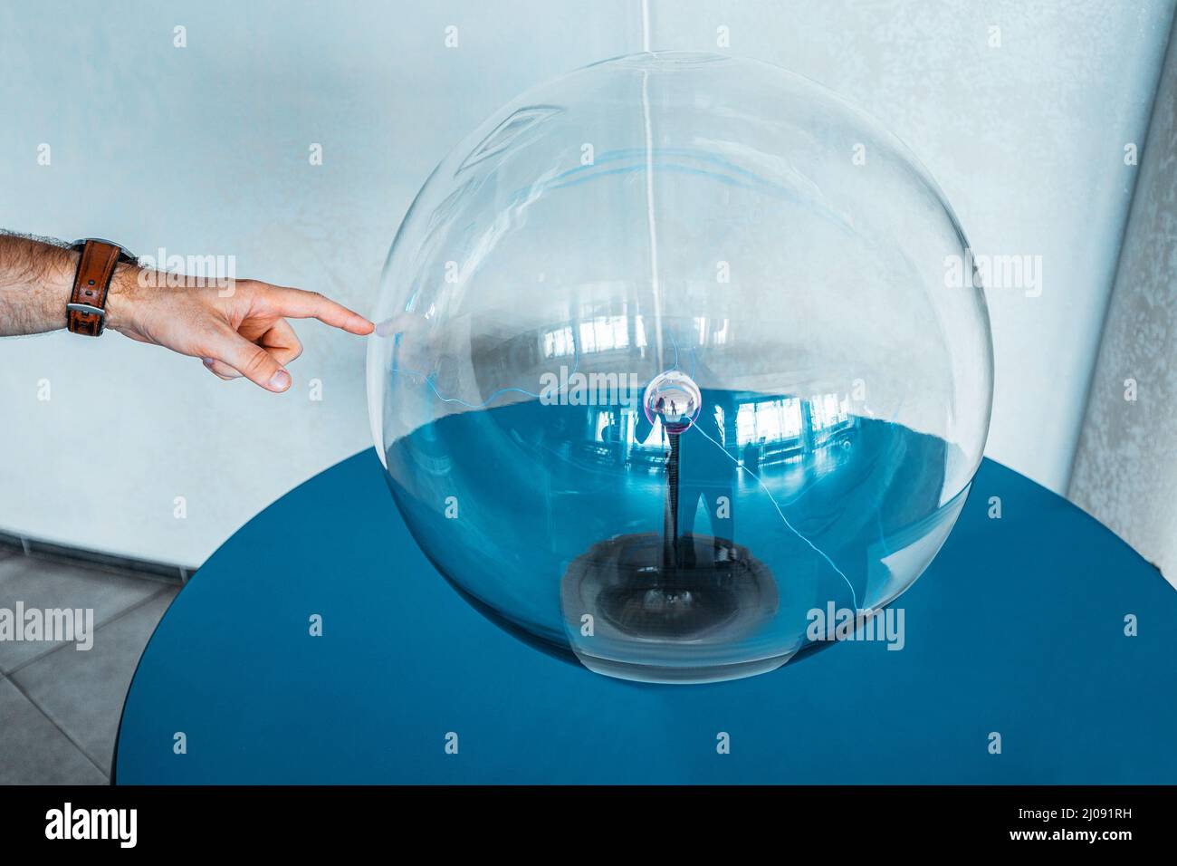 People touch the plasma ball causing sparks of energy at the museum of