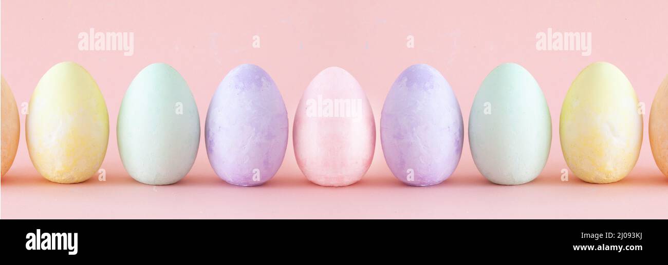 Pastel Easter eggs standing a row . Easter decoration on pink coloured background Stock Photo