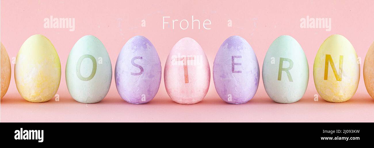 Pastel Easter eggs with text standing a row . Easter decoration on pink coloured background Stock Photo
