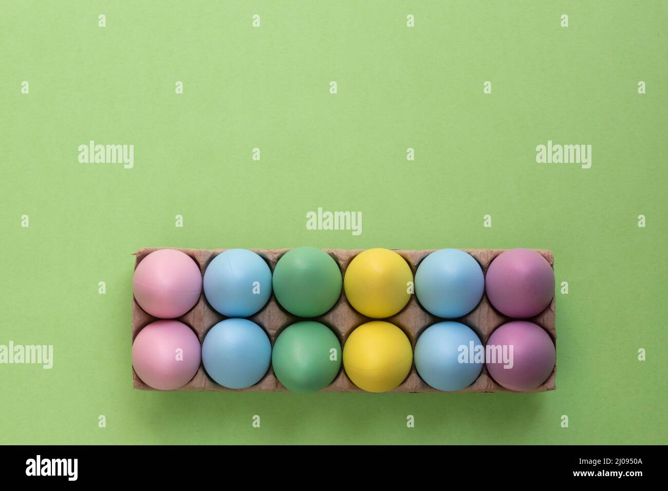 Easter wallpaper background. Colorful easter eggs in egg carton Stock Photo