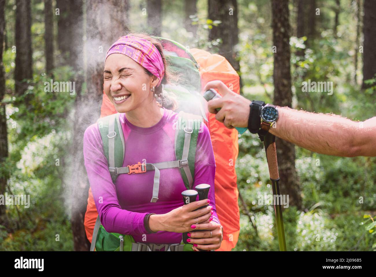 A female hiker sprays an aerosol to protect against bloodsucking