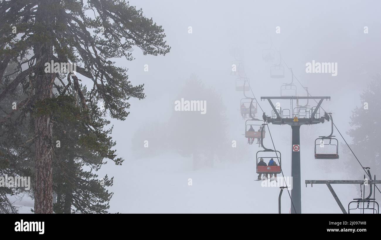 Ski lift in the fog, winter sports in bad weather. Mount Olympus ski resort, Cyprus Stock Photo