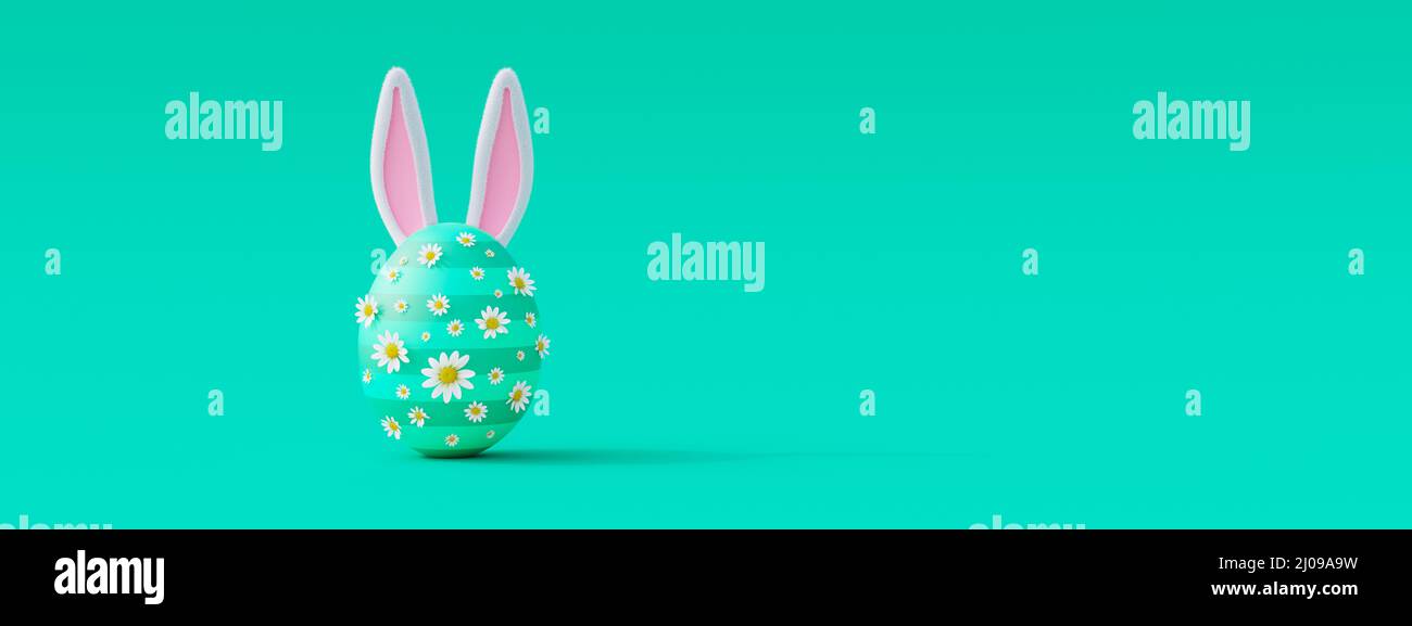 Creative Easter egg with flowers and bunny ears on green background ...