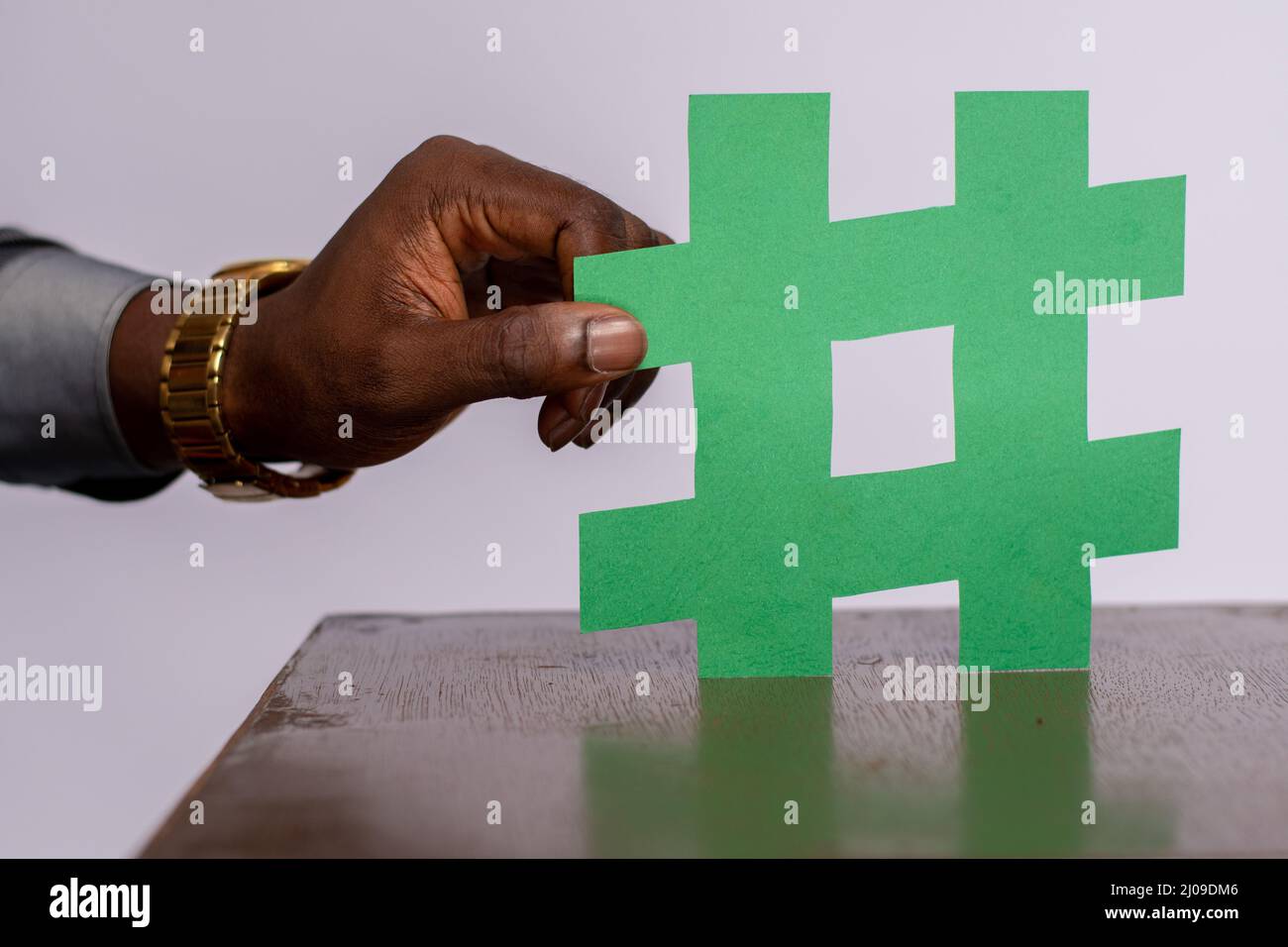 Closeup of an African man's hand holding a paper cut out of a green ...