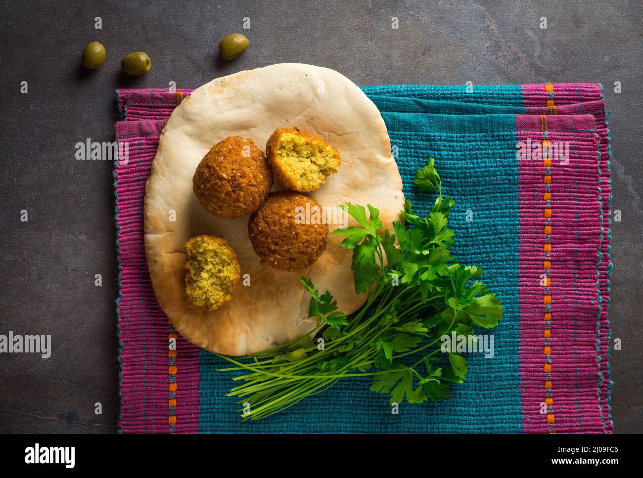 Popular Middle eastern street food- Falafel and kuboos. Top view of delicious fried Falafil placed on the Khuboos or pita bread. Stock Photo