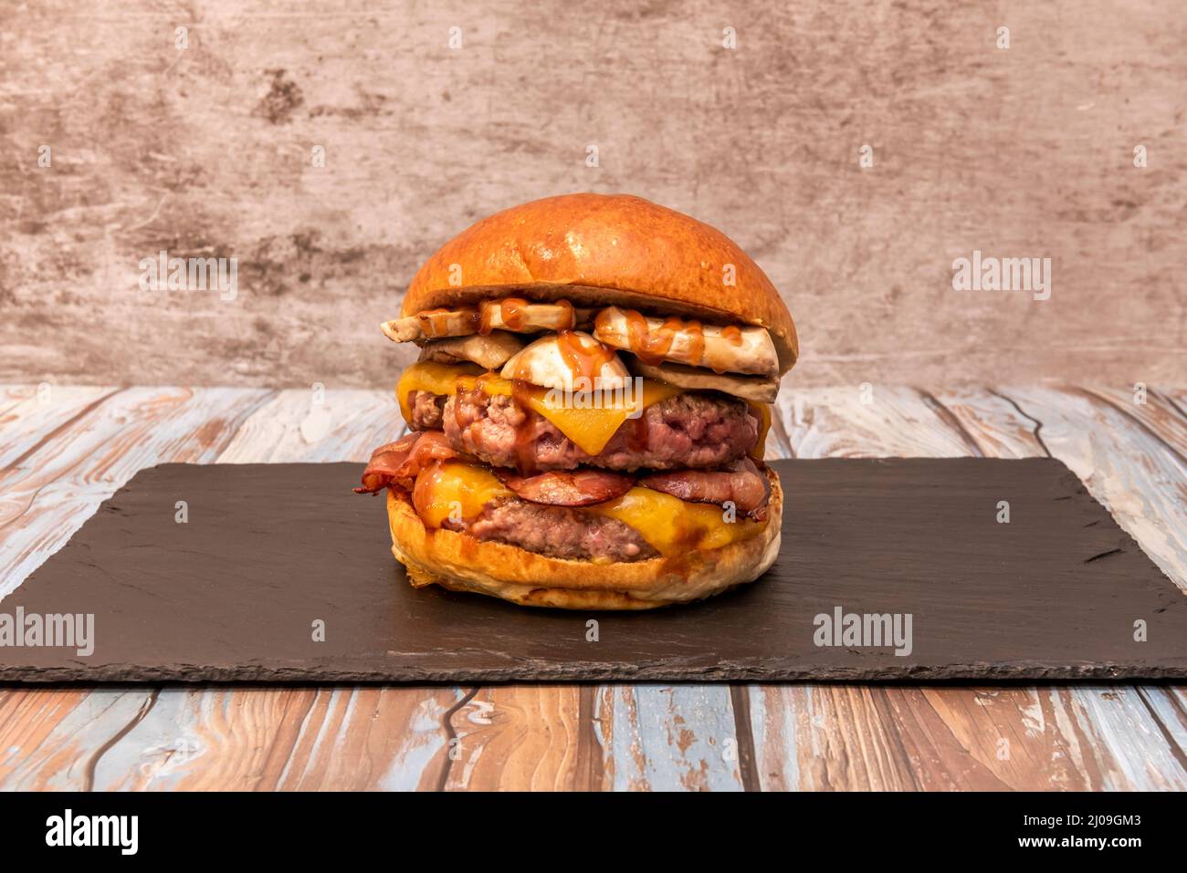 Beast burger with double beef, double cheddar cheese, stewed mushrooms, fried bacon and barbecue