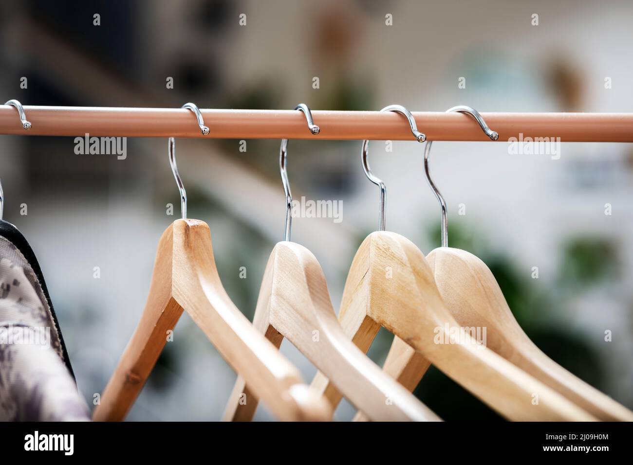 Wooden hangers to hang clothes on a light brown coat rack Stock Photo