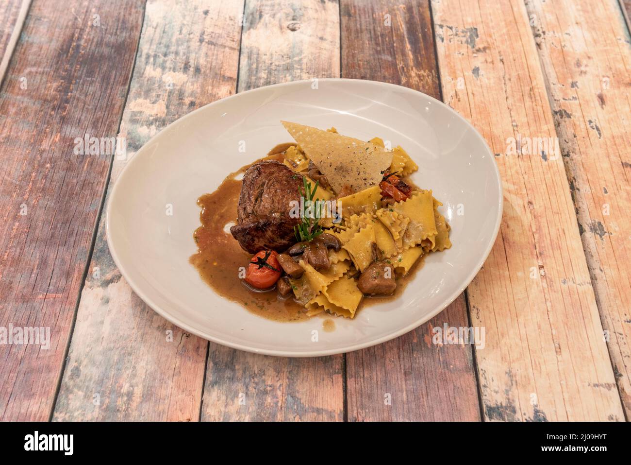 sirloin steak with cream and fresh pasta. Chop the sirloin into small cubes with salt and pepper and fry with the minced garlic over high heat. Stock Photo