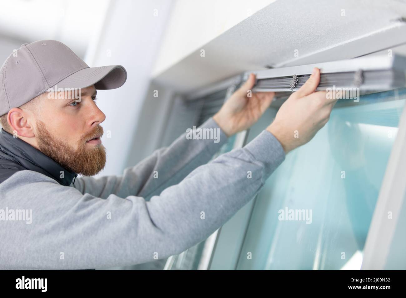 man installing cassette roller blinds on windows Stock Photo
