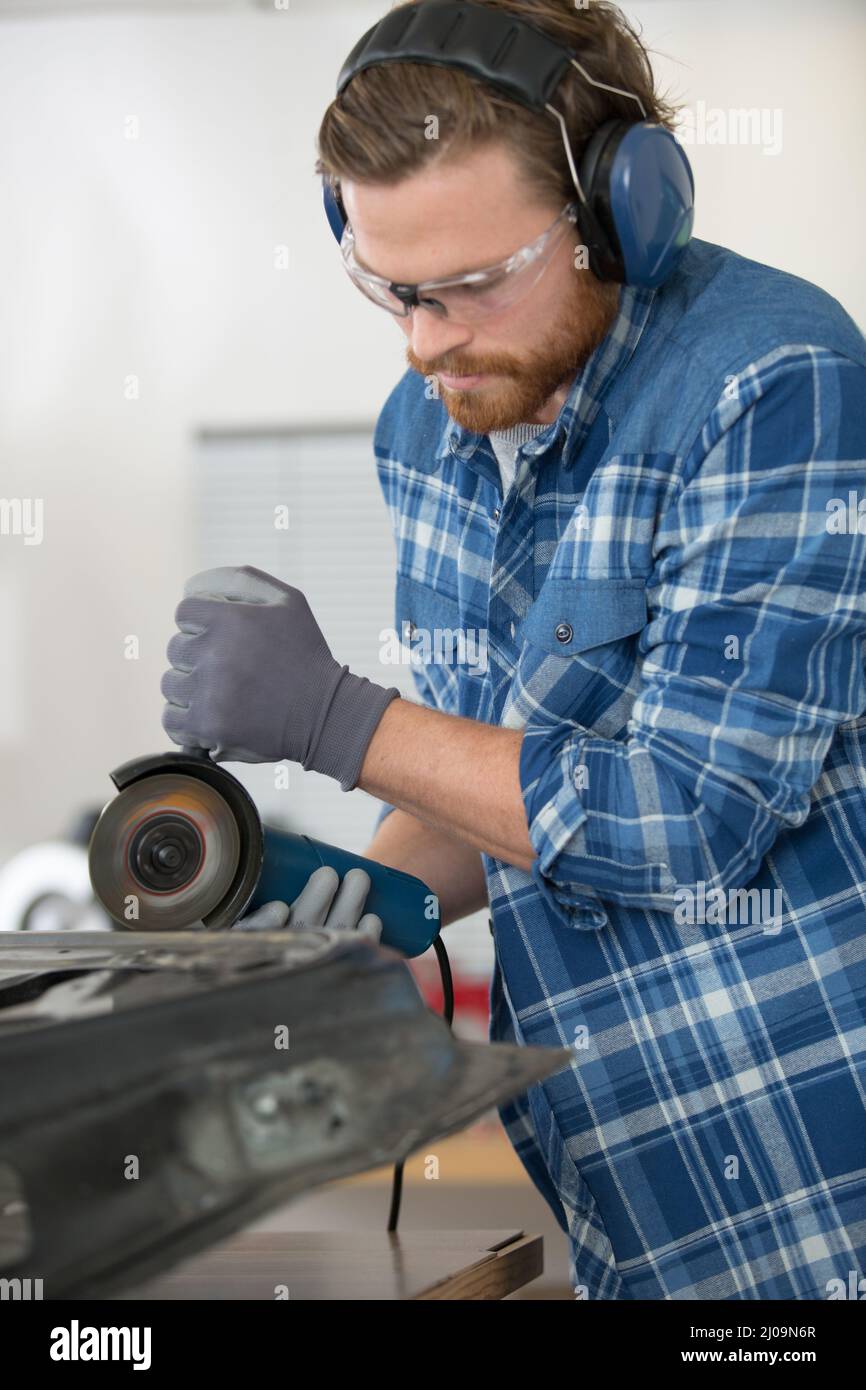 man mechanical worker repairing with electric grider Stock Photo