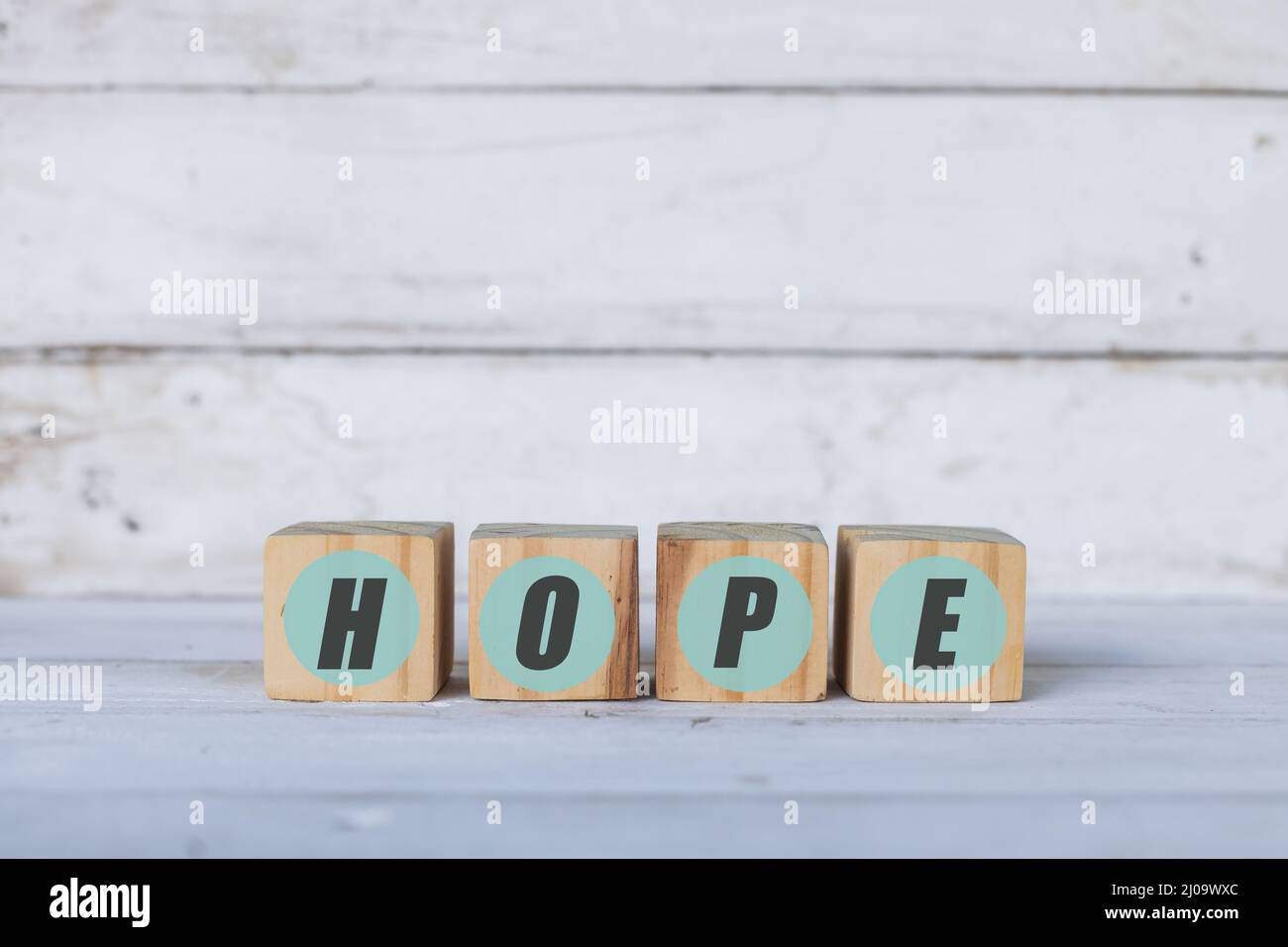 hope concept written on wooden cubes or blocks, on white wood background. Stock Photo