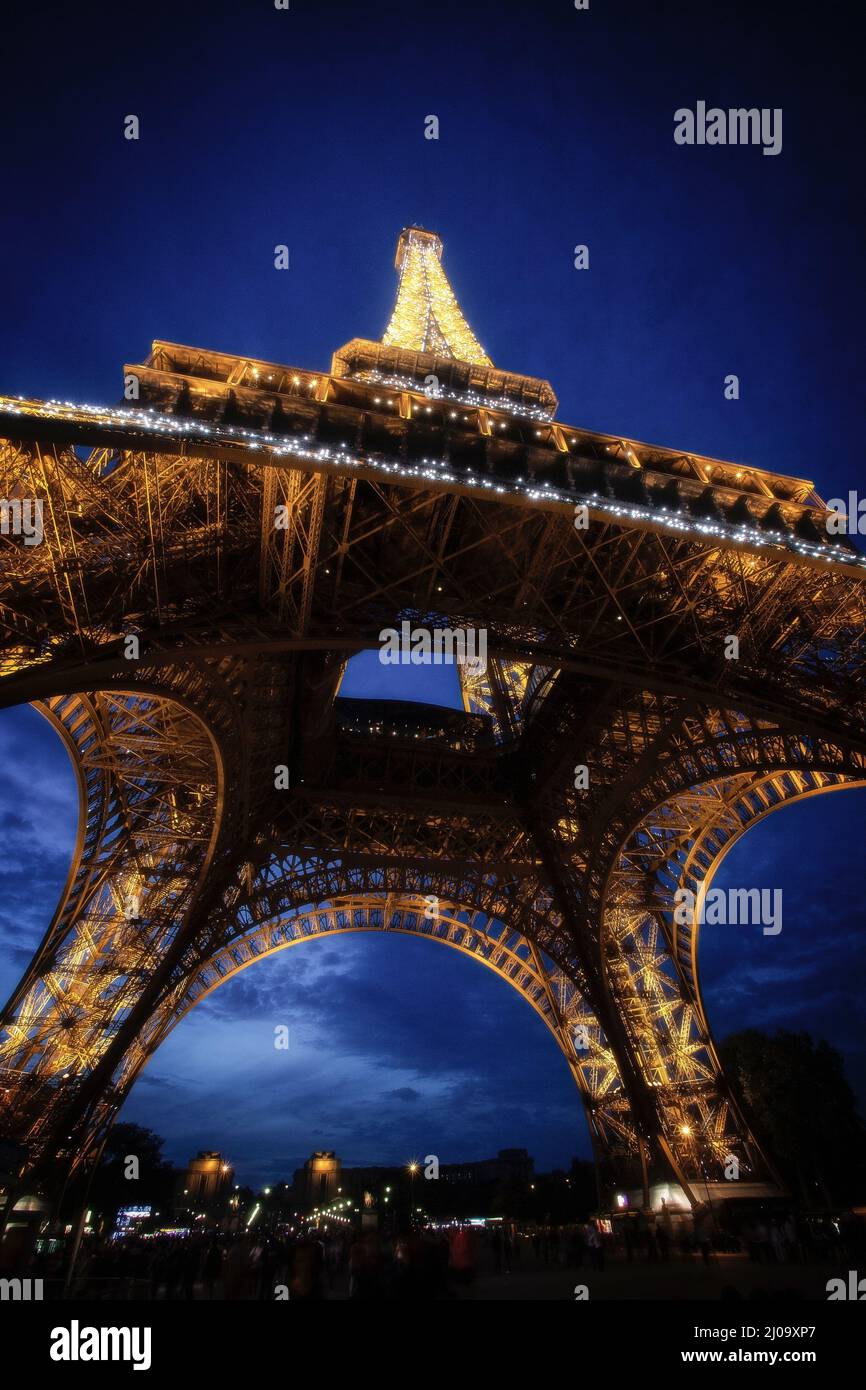 The Eiffel Tower beams with light at dusk. Paris, France Stock Photo