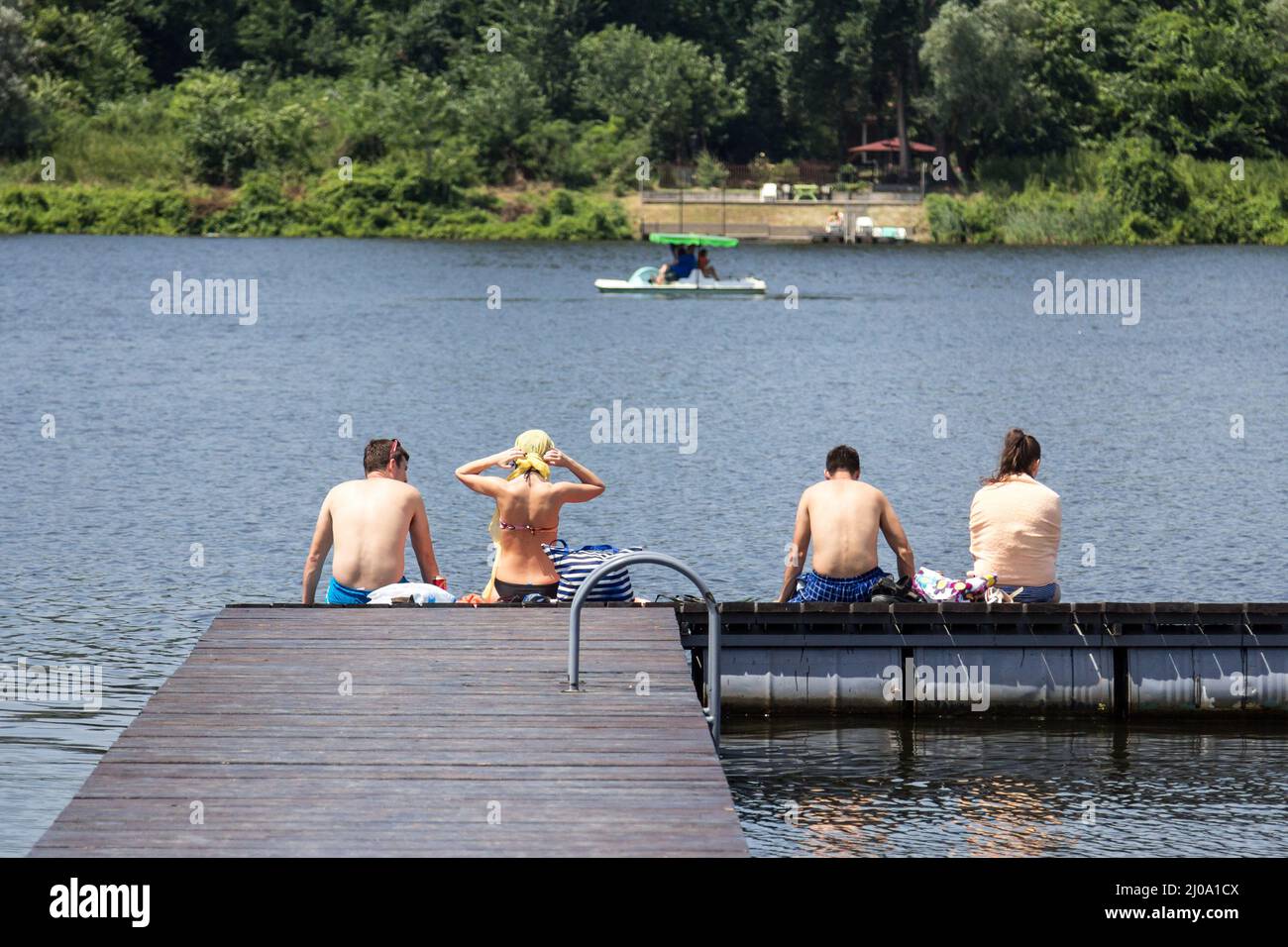 VELIKO GRADISTE, SERBIA - JUNE 26, 2016: Four people in bathing suit in front of Srebrno Jezero, in Serbia, getting ready to swim while on holiday, re Stock Photo