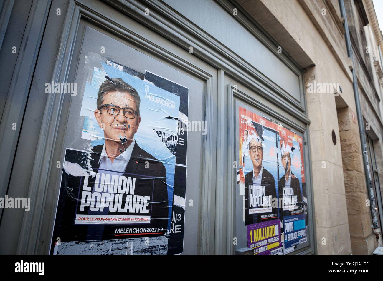 BORDEAUX, FRANCE - FEBRUARY 19, 2022: torn posters of Jean Luc Melenchon in Bordeaux for the French 2022 presidential elections. Melenchon is the lead Stock Photo