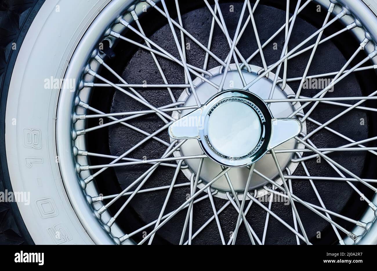 Antique chrome spoke wheel with white-faced rubber and center nut Stock ...