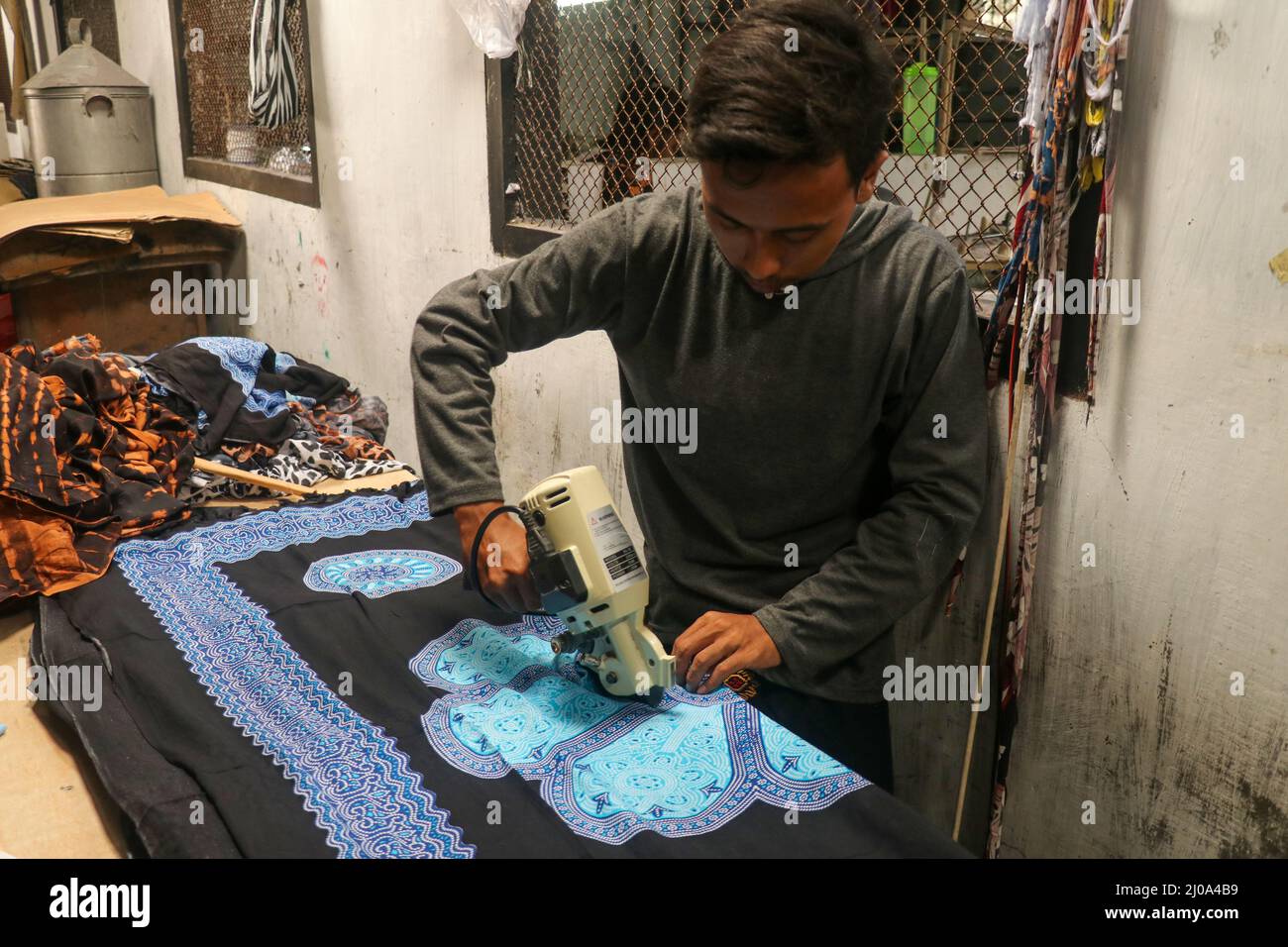 Electric cutter Fabric Machine. Cutting a fabrics in an Man cutting edge of fabric